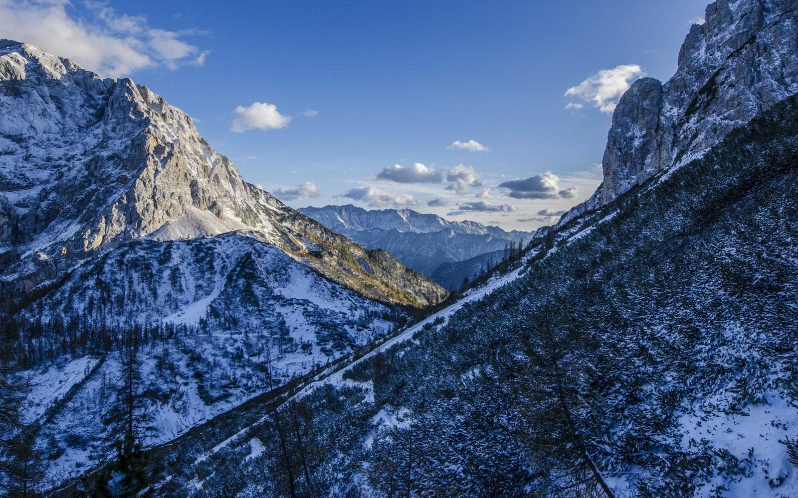 An empty mountain road curving through switchbacks in morning light